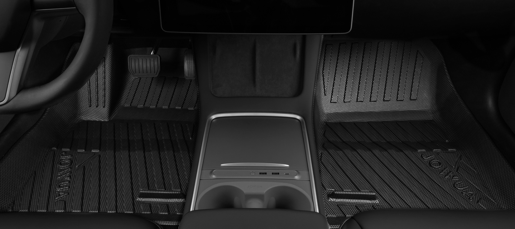 Car interior showing the center console and footwells with textured floor mats and visible pedals. The design is sleek and modern, with a minimalist aesthetic.