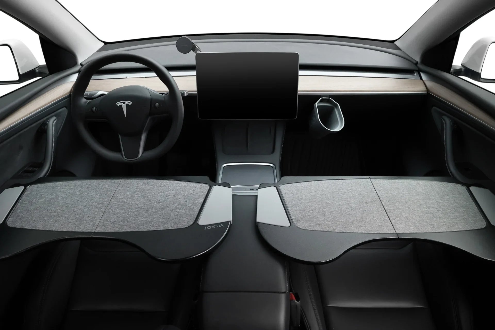 Interior view of a modern car focusing on the steering wheel, touchscreen display, and dashboard. The design is minimalist with wood accents and a clean, sleek layout. A unique foldable desk feature is visible.