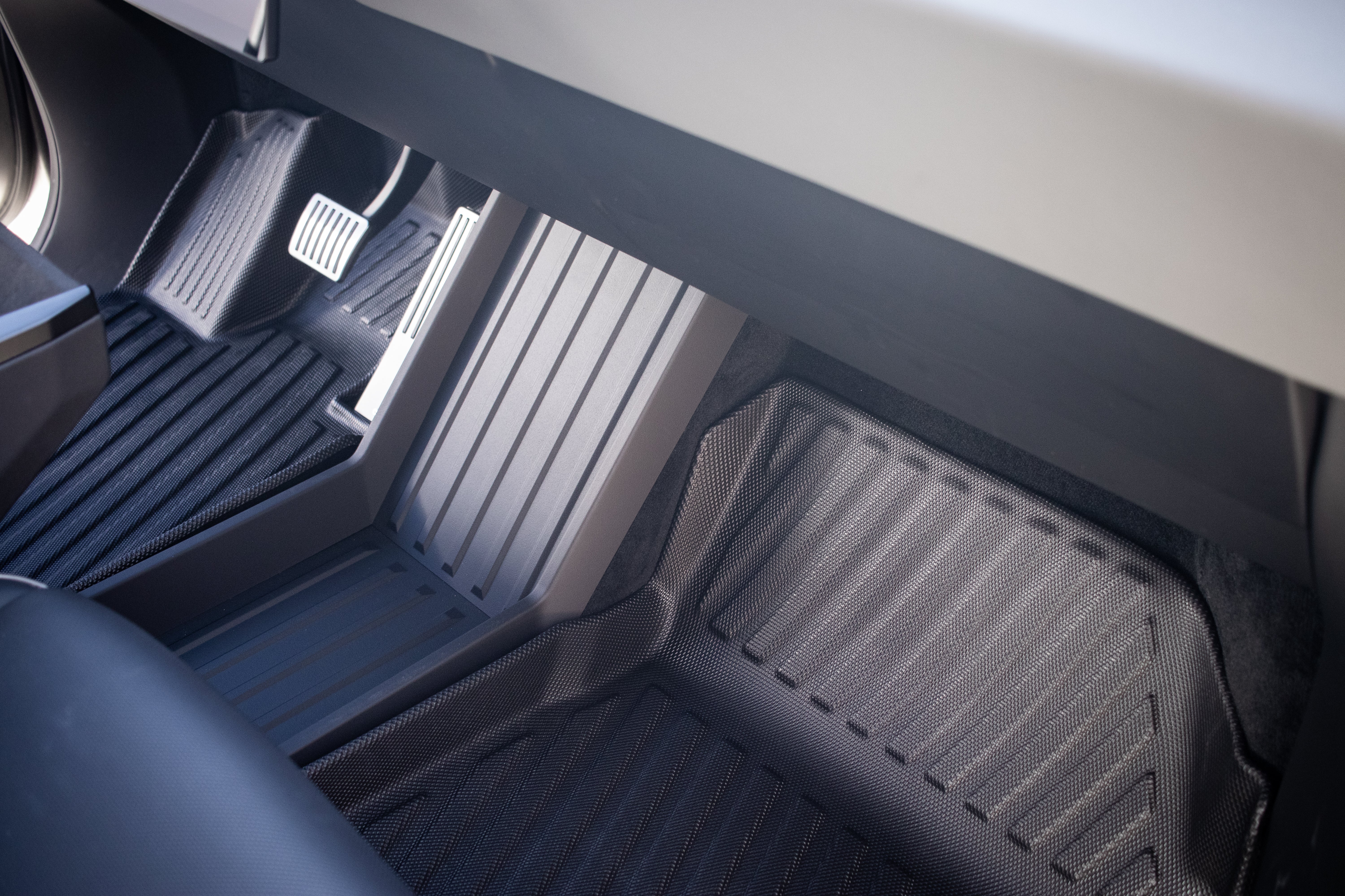 JOWUA's All Weather Floor Liners for the Tesla Cybertruck feature a sleek, grooved design in both the driver's footwell with three pedals and the passenger's side. These durable liners blend style and functionality, perfect for rugged use.