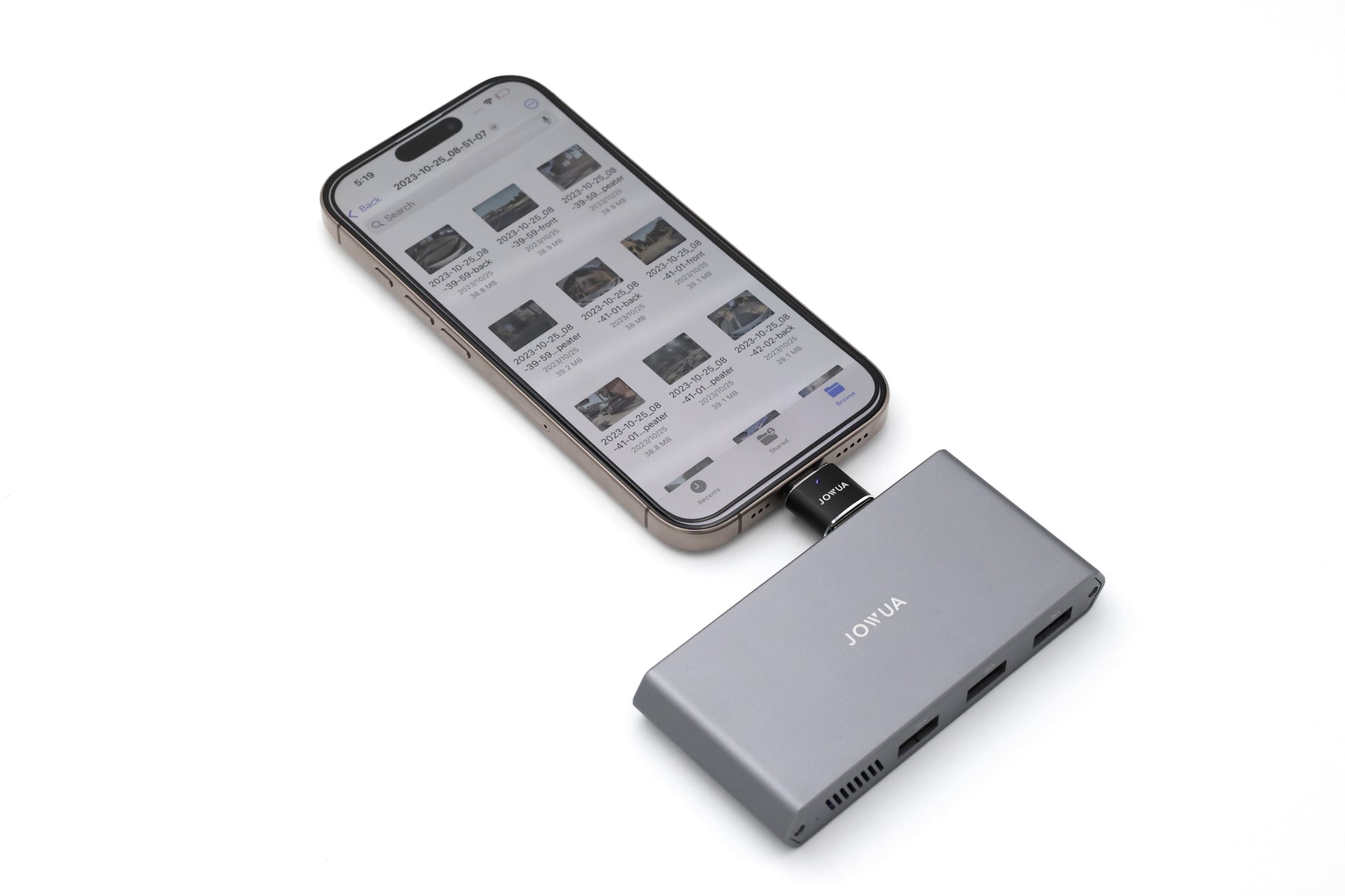 A smartphone connected to a silver JOWUA Tesla 1TB SSD + 3-Port HUB displays a webpage with text and images. This hub, crafted for Tesla Owners’ Data Transmission, features multiple ports for enhanced connectivity. Its sleek design blends seamlessly with the plain white background.