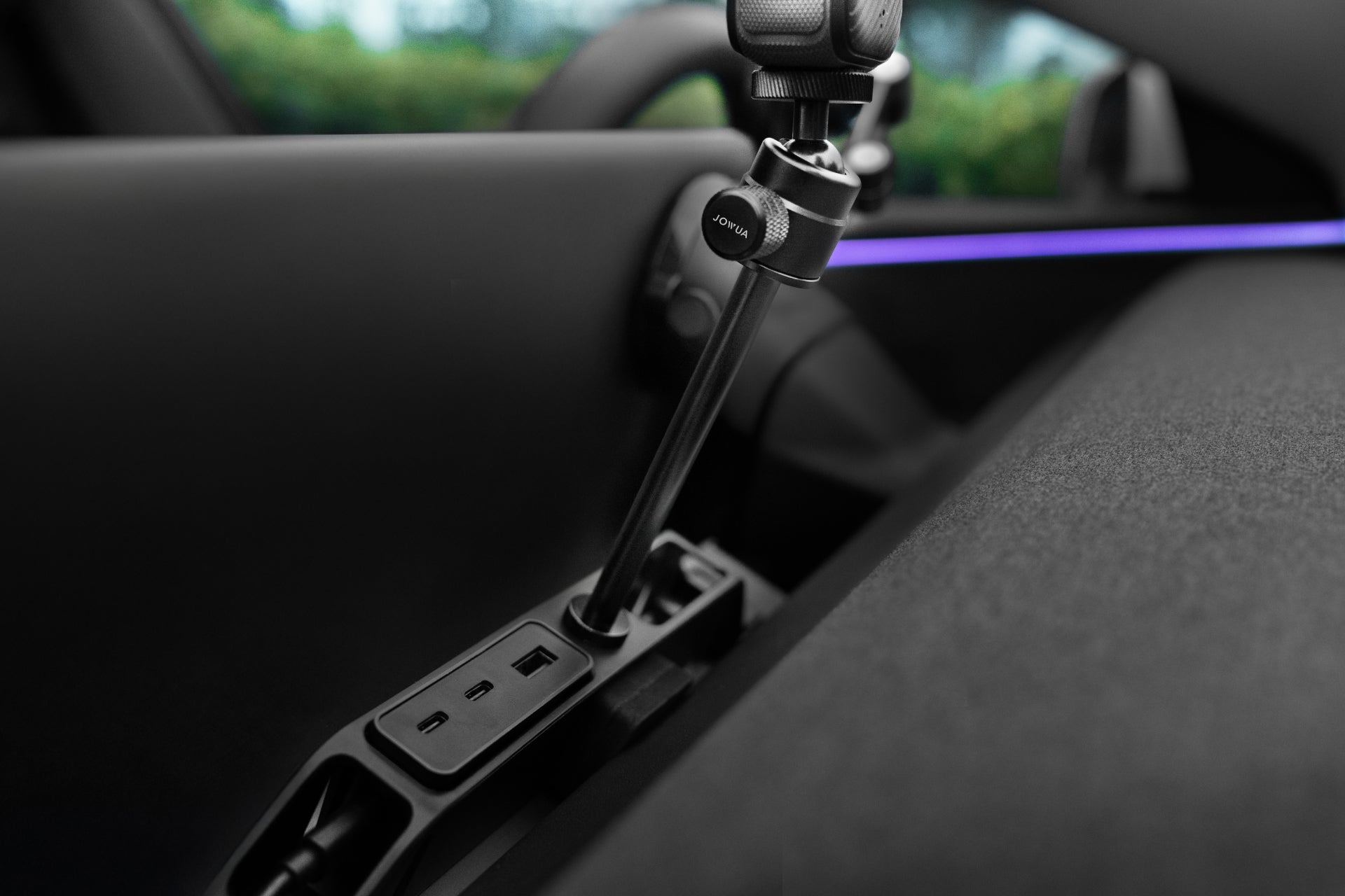 The car console displays a JOWUA 360 ° Multi Function Mount with an attached GoPro. The sleek, black dashboard features a purple ambient light strip enhancing this photography setup.