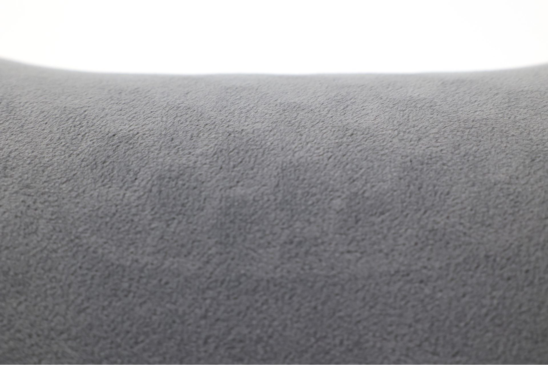 Close-up of the gray, fuzzy fabric surface of the JOWUA Car Neck Pillow, showcasing its soft fleece material and slightly curved ergonomic design. The background is out of focus, offering a smooth and minimalistic look perfect for neck support.