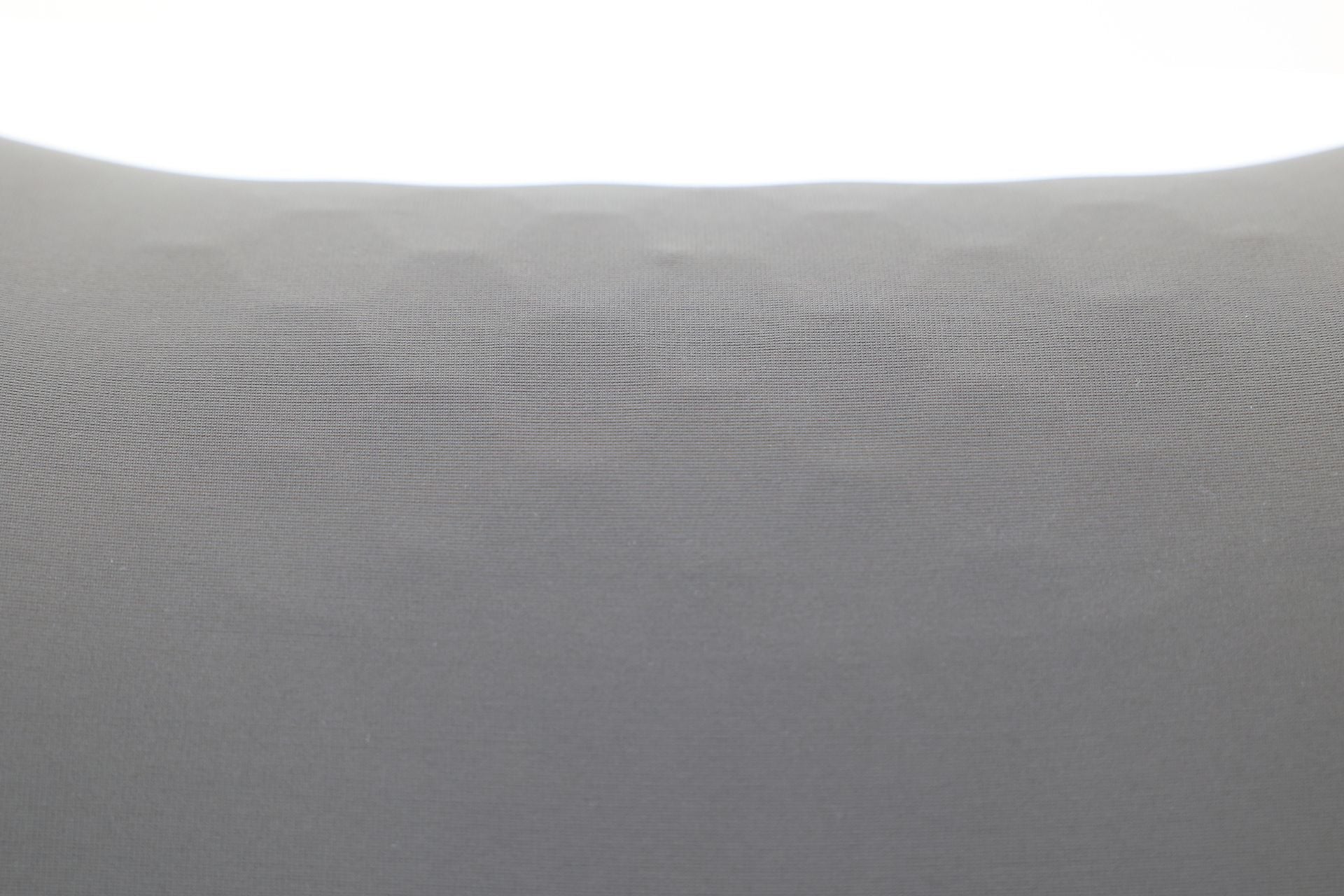 A close-up of the JOWUA Car Neck Pillow reveals its textured gray surface with a subtle hexagonal pattern, highlighting the intricate dual-material design under even lighting.