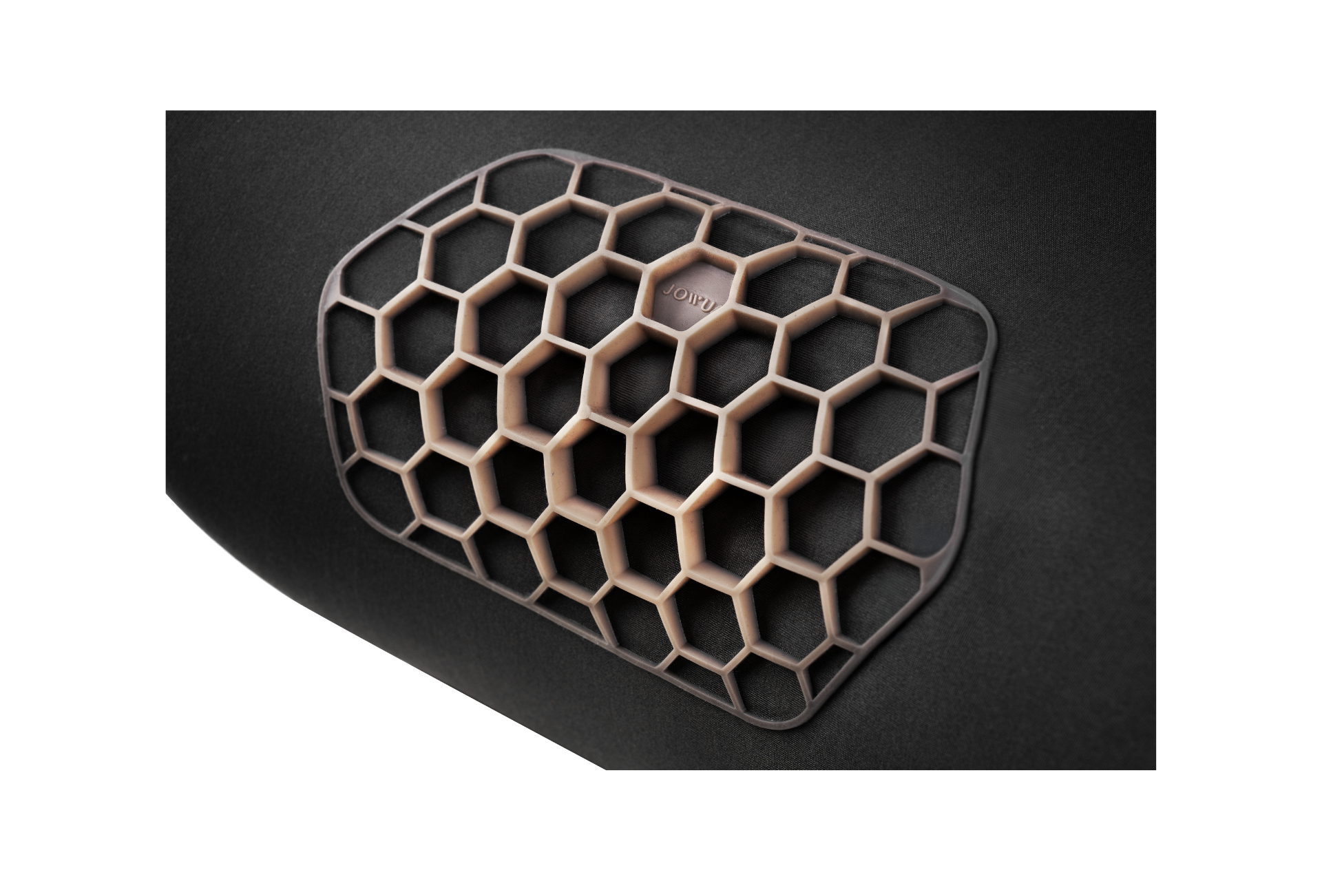 Close-up of a hexagonal, honeycomb TPE-shaped grille on a dark surface, showcasing the ergonomic design and raised geometric pattern with a matte finish of the JOWUA Car Neck Pillow.