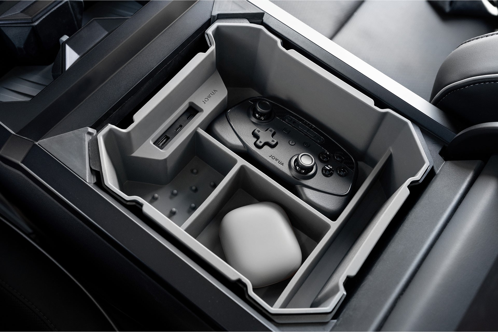 The JOWUA Center Console Set for the Tesla Cybertruck features premium silicone dividers with sections for a game controller, a small white device, and USB ports, ensuring efficient organization.