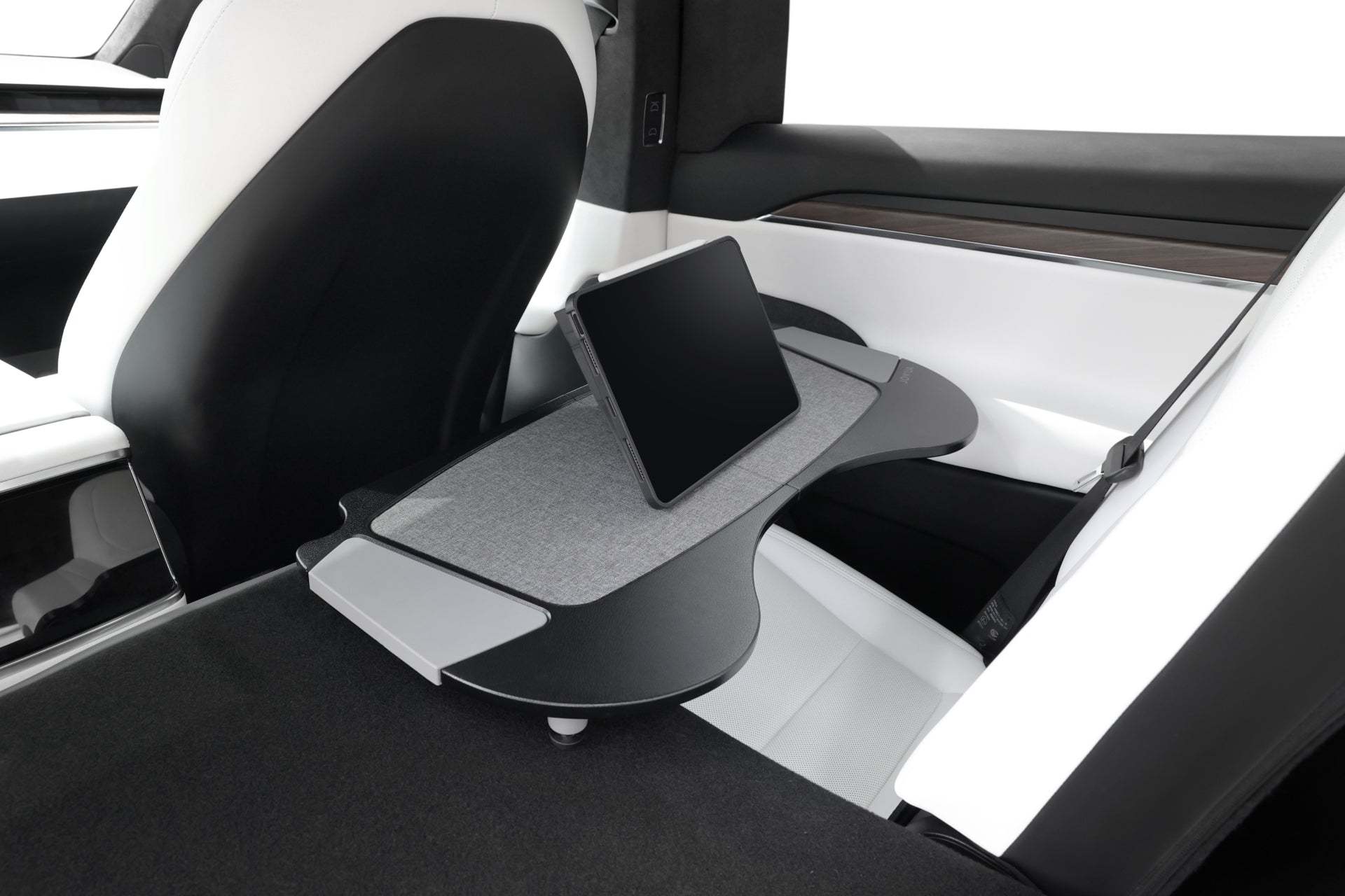 The image features the interior of a Tesla Model X, with premium accessories prominently displayed. In the backseat, a JOWUA Foldable Car Tray is extended to hold a tablet. Both the seat and table are elegantly designed in sleek black and white tones with minimalist aesthetics and adorned in premium PU leather for an added touch of luxury.