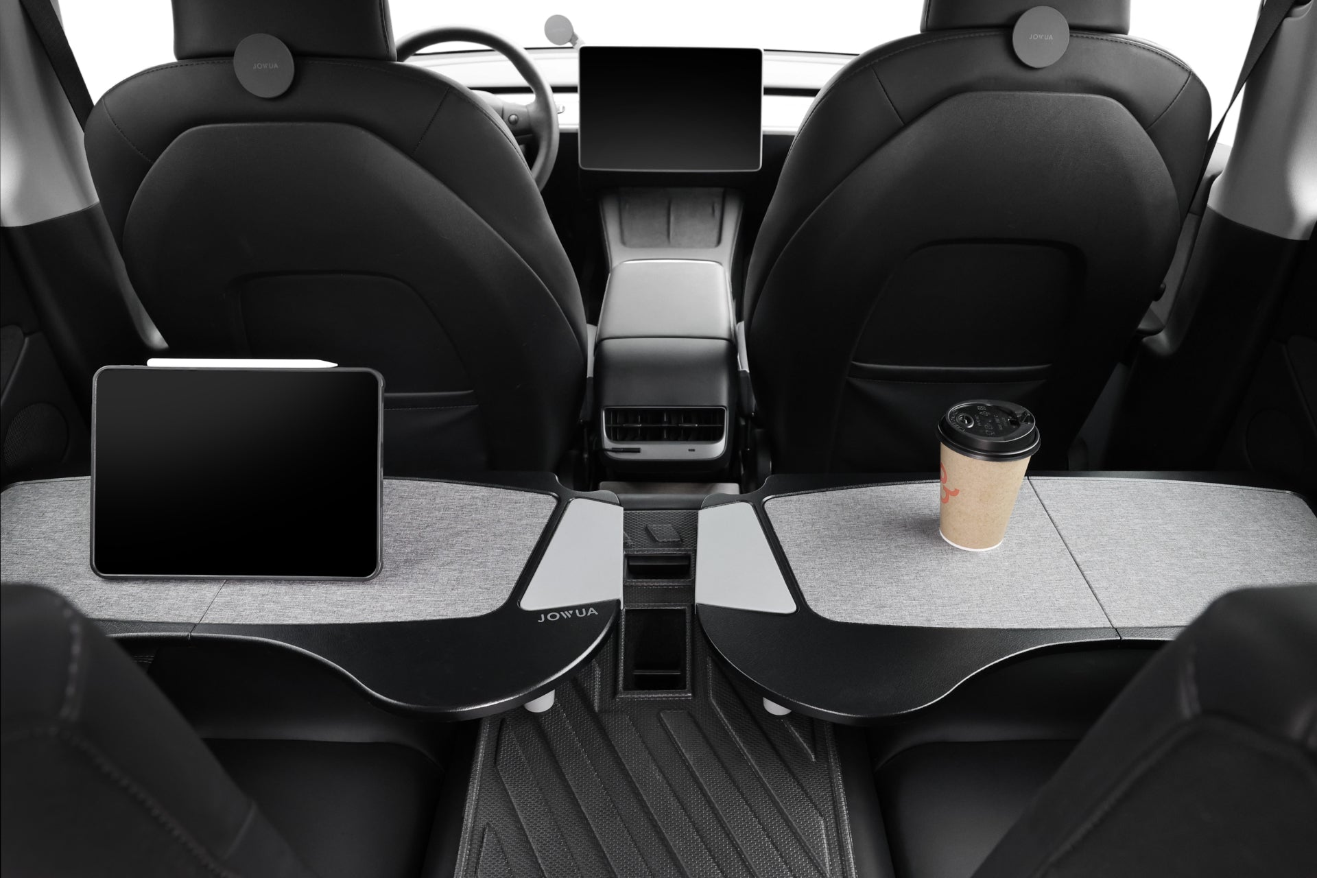 The interior of the contemporary Tesla Model S features premium PU leather seats paired with JOWUA's Foldable Car Tray for Tesla, which includes digital tablets mounted on them. A cup of coffee sits gracefully on one tray, as seen from the back seat, emphasizing the sophisticated design and cutting-edge technology.