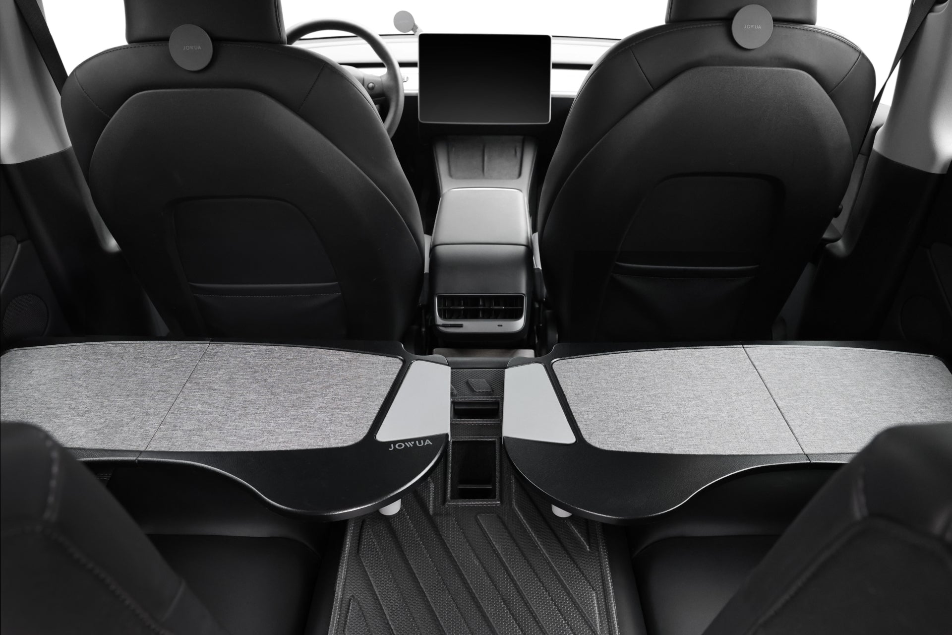 The interior view of this modern car showcases two black front seats crafted from premium PU leather, complete with built-in headrests. The dashboard features a central screen, while the back area highlights sleek accessories from JOWUA, including the Foldable Car Tray for Tesla models S/3/X/Y.