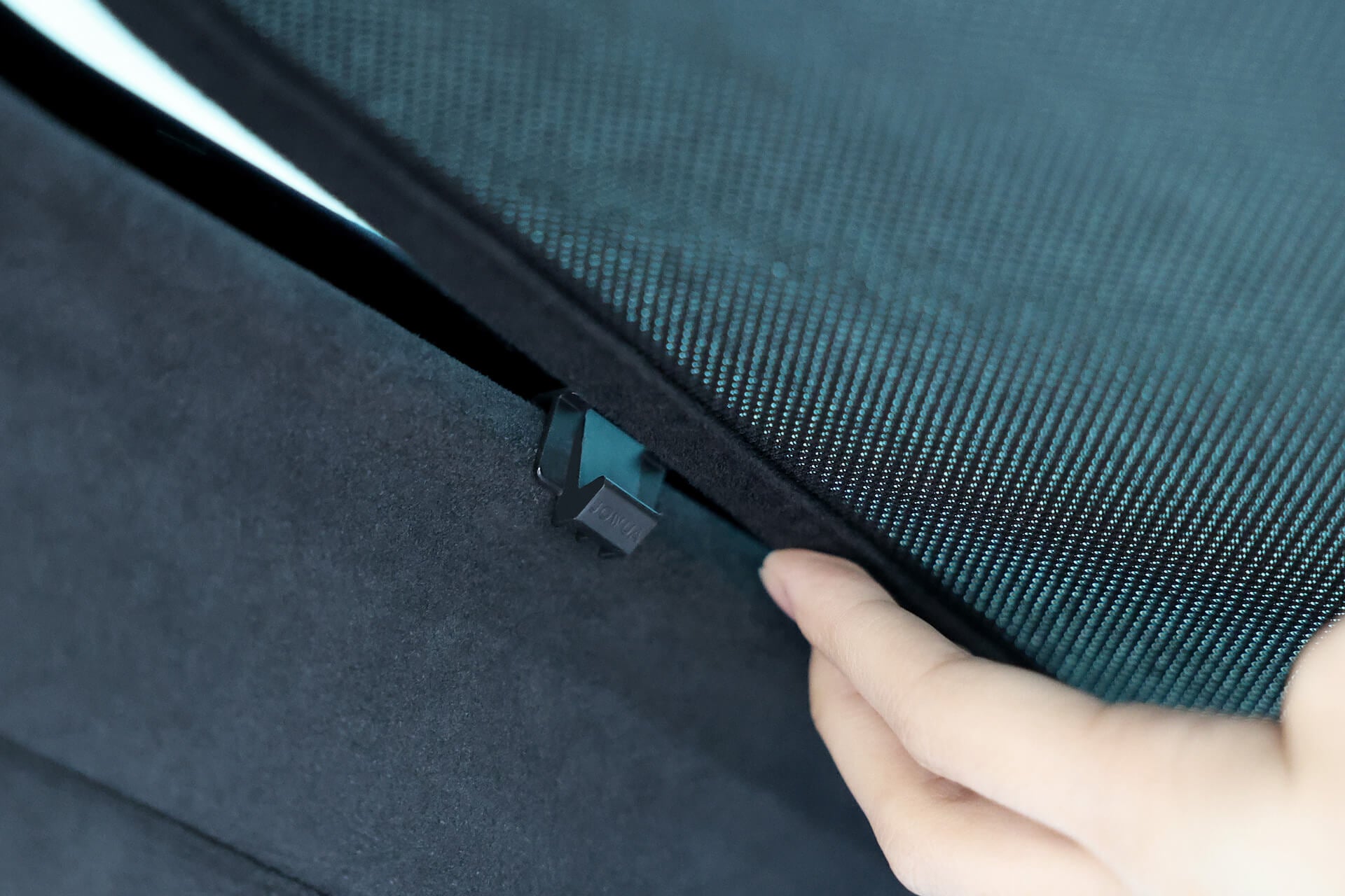 A close-up photo shows a hand raising a fabric flap with a "LOCK" latch on the Glass Roof Sunshade-Mesh (Model X) by JOWUA, highlighting its dual function as UV protection. It boasts an elegant teal and black color scheme.