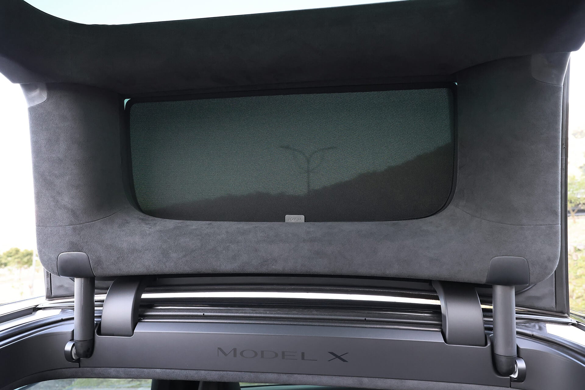 Interior view of a Tesla Model X with the rear hatch open, revealing the JOWUA Model X Separate Sunshade Bundle for heat insulation. The vehicle's trim and part of the rear window frame are visible, showcasing the sleek integration of this sunshade.