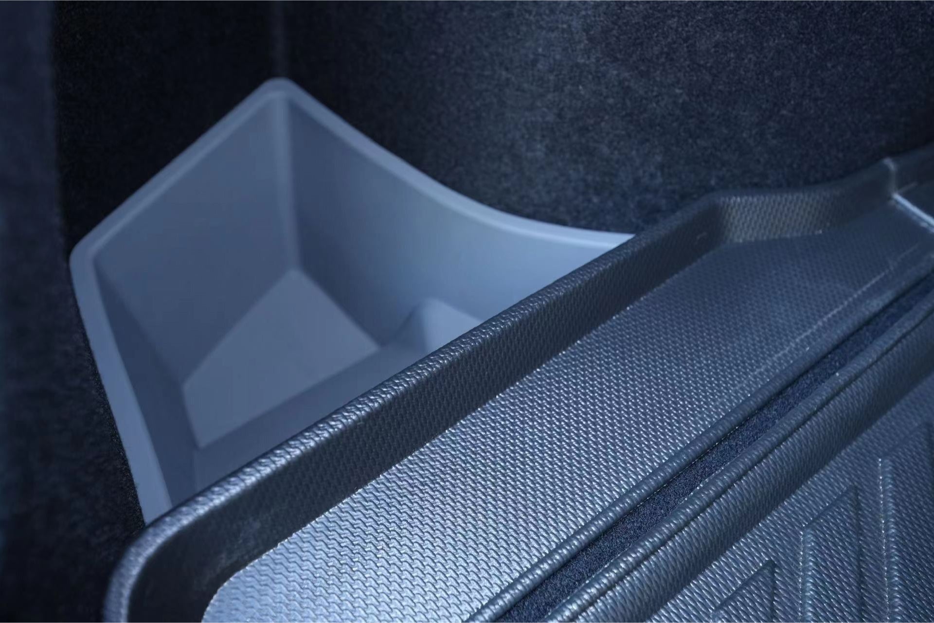 Close-up of the JOWUA Trunk Storage Bins for Tesla Reengineered Model 3 Highland (2024+), featuring an organized storage area with a textured cargo liner and a premium silicone storage compartment. The liner's grid pattern beautifully complements the light gray compartment, which fits perfectly into the trunk space.