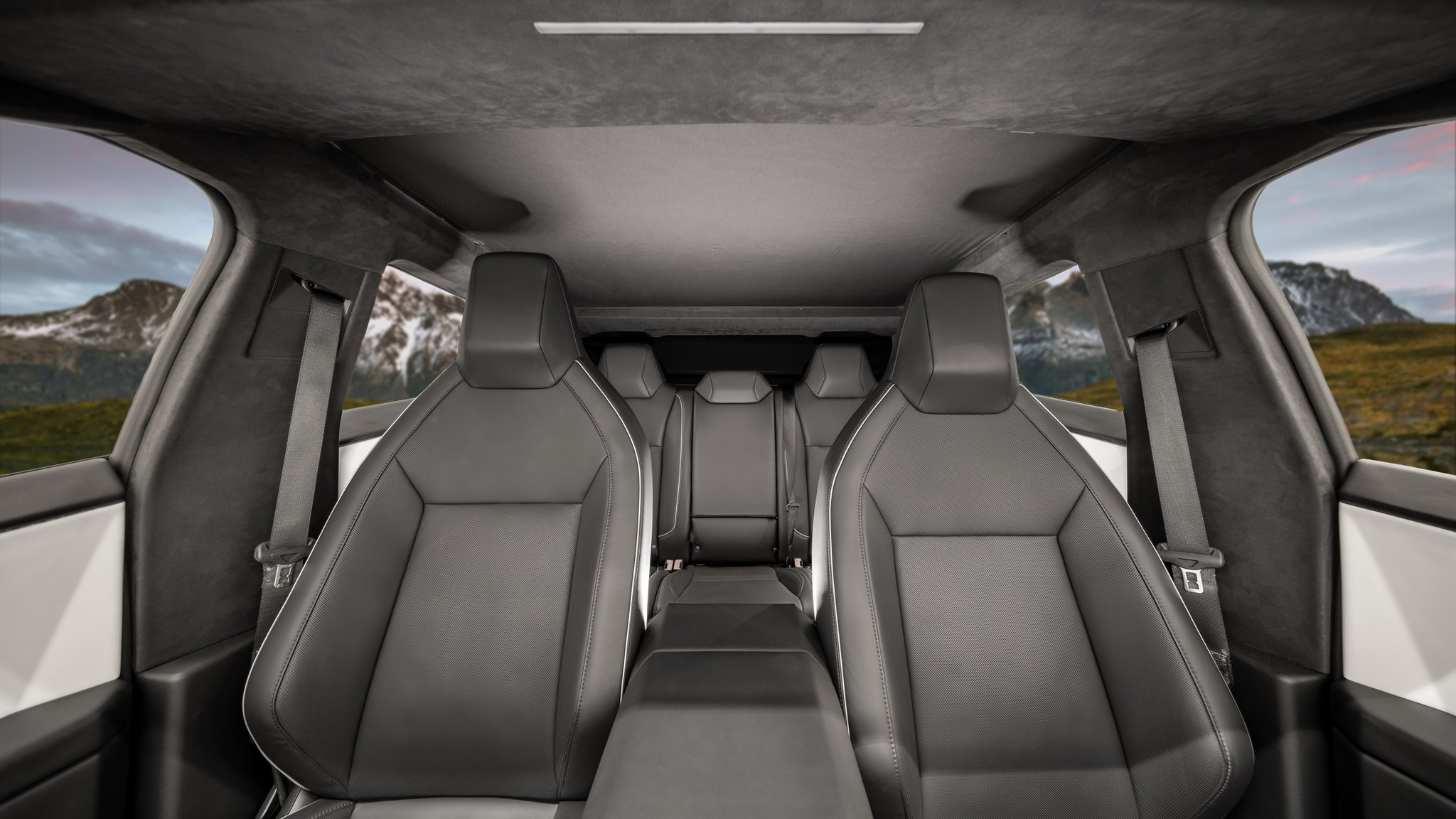 Interior view of a vehicle showcasing modern black leather seats and minimalistic design, with large windows featuring the JOWUA Cybertruck Glass Roof Sunshade for UV protection, offering a scenic mountain landscape in the background.